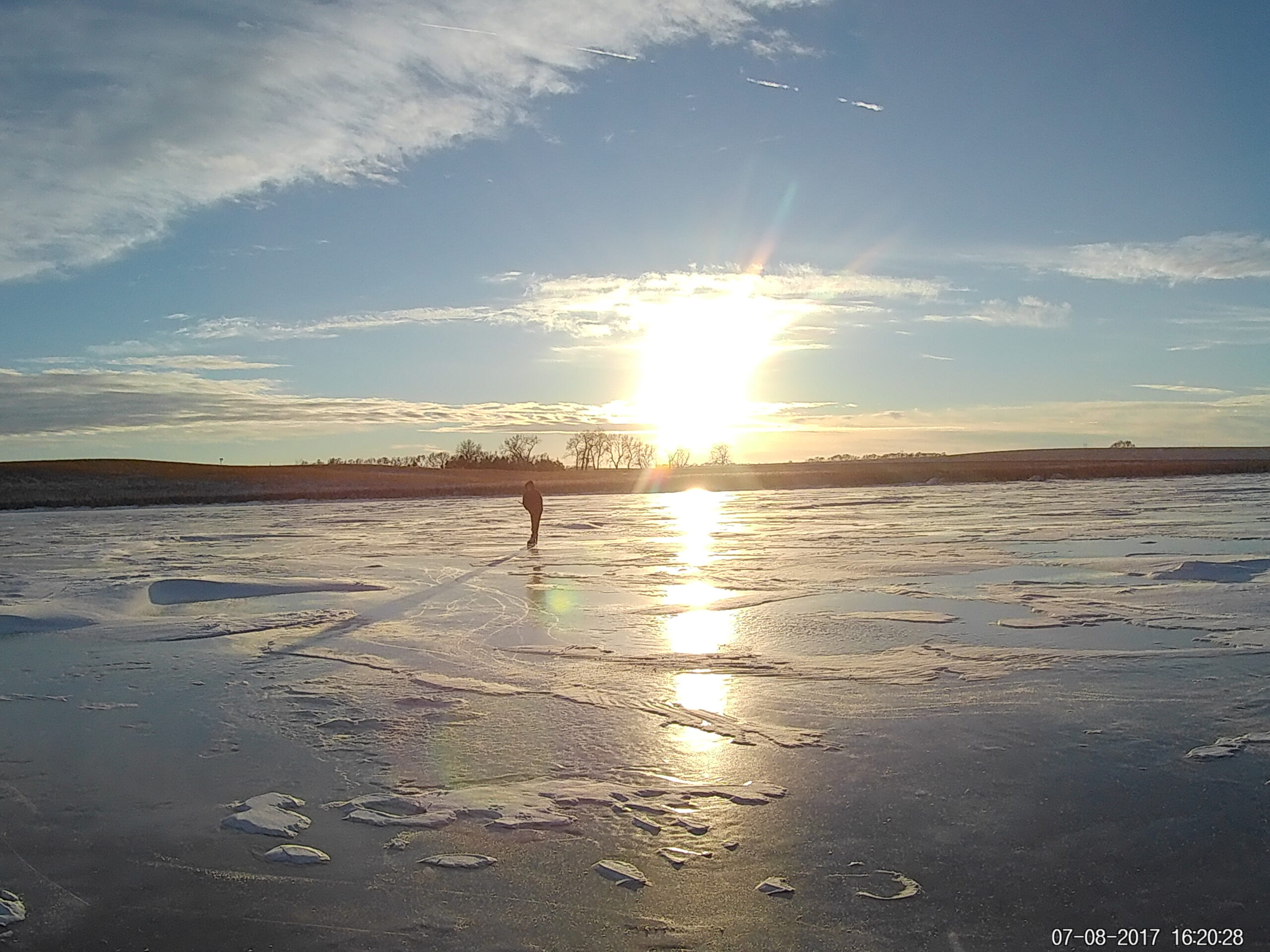 Ice Skating at Sunset on Pond